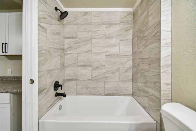 bathroom with tiled shower / bath combo and toilet