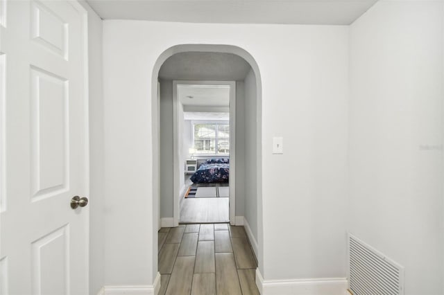 3419 19th St E, Bradenton, FL 34208 - corridor featuring arched walkways, light wood finished floors, visible vents, and baseboards