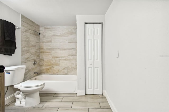 bathroom featuring tiled shower / bath combo and toilet