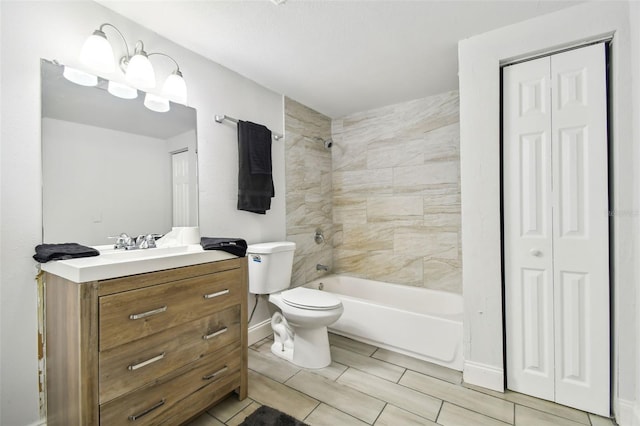 full bathroom featuring tiled shower / bath, vanity, and toilet