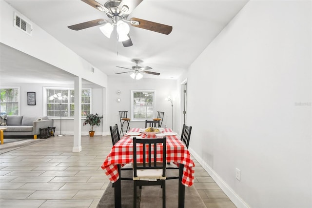 dining area with light wood-type flooring, a healthy amount of sunlight, and ceiling fan