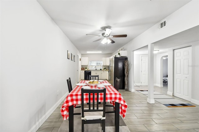 dining room with sink, ceiling fan, and light hardwood / wood-style flooring