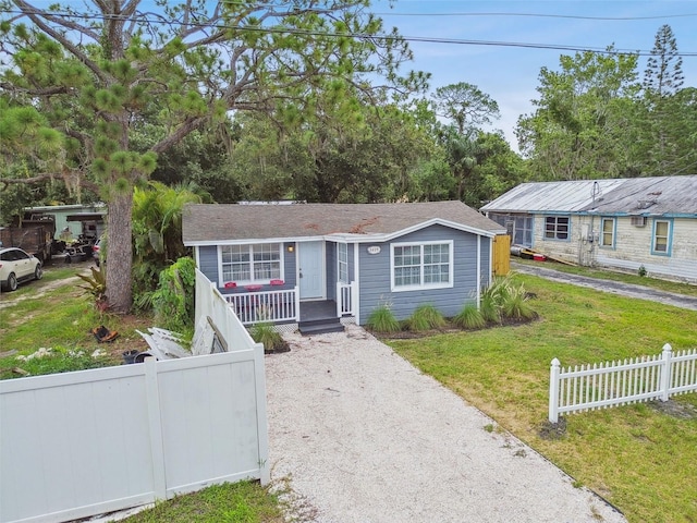 ranch-style home featuring a front lawn and covered porch