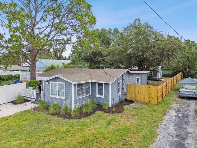 3419 19th St E, Bradenton, FL 34208 - view of side of home featuring a lawn, a gate, fence, and aphalt driveway