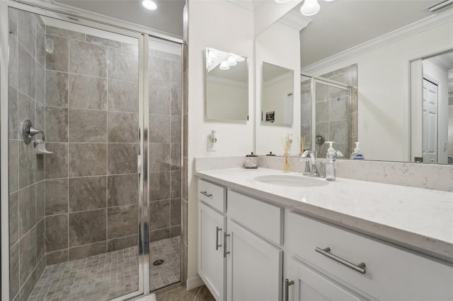 bathroom featuring vanity, a shower with shower door, and ornamental molding