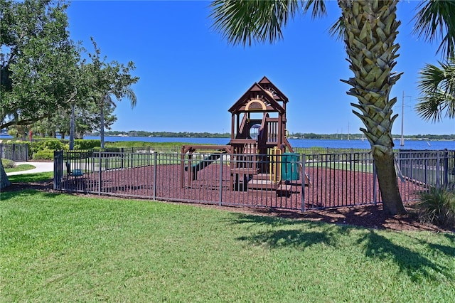 view of jungle gym with a lawn and a water view