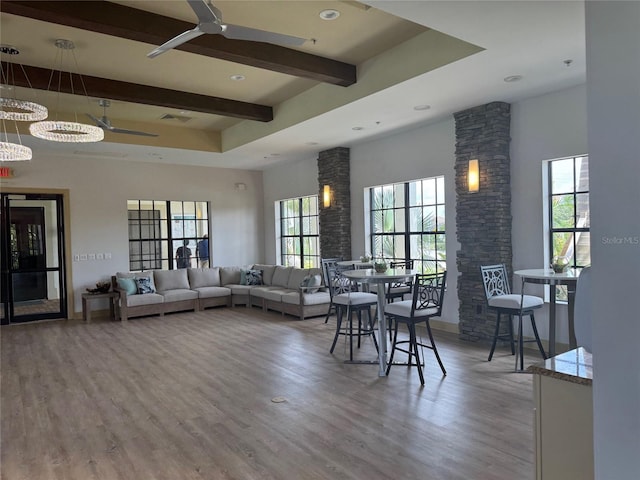 living room with beamed ceiling, wood-type flooring, and ceiling fan