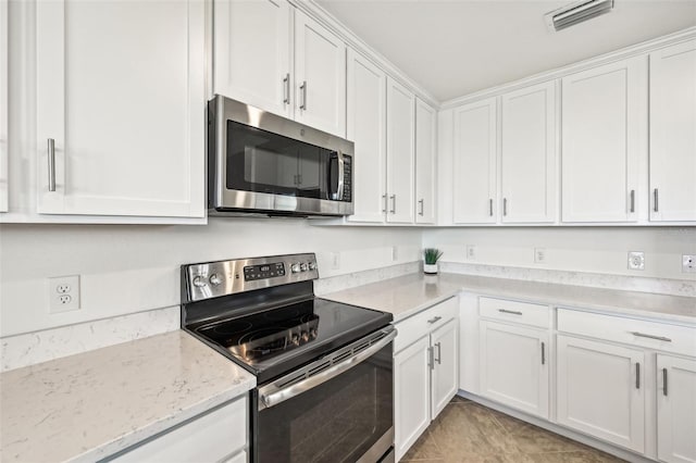 kitchen with white cabinetry, stainless steel appliances, and light stone counters