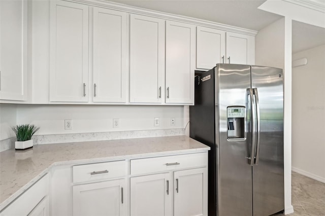 kitchen featuring tile patterned floors, white cabinetry, light stone counters, and stainless steel refrigerator with ice dispenser