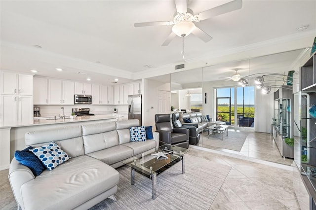 tiled living room featuring ceiling fan, ornamental molding, and sink