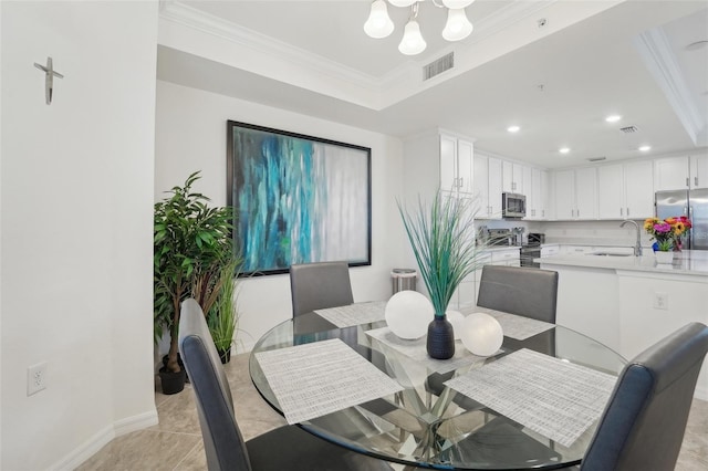 dining room featuring crown molding, light tile patterned floors, sink, and a chandelier