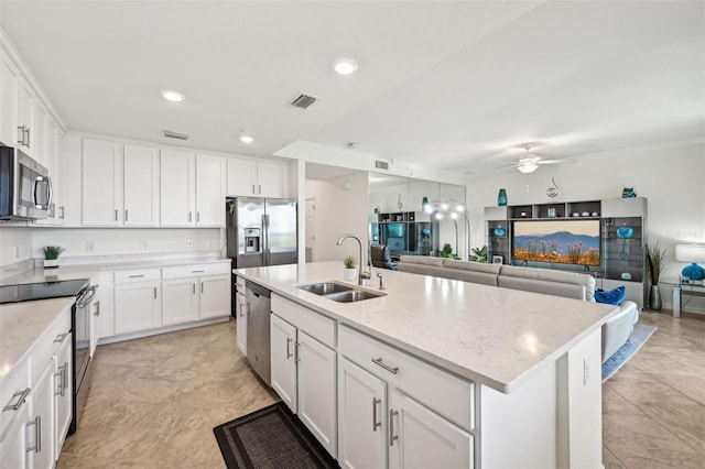 kitchen featuring white cabinetry, a kitchen island with sink, sink, and appliances with stainless steel finishes