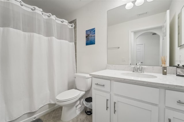 full bathroom with tile patterned floors, shower / bath combo with shower curtain, vanity, and toilet