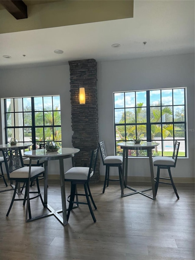 dining space featuring beamed ceiling and wood-type flooring