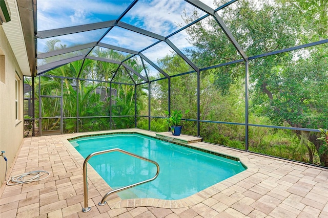 view of swimming pool with glass enclosure and a patio area