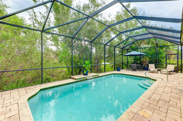 view of swimming pool featuring glass enclosure and a patio