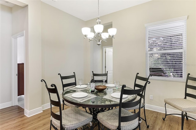 dining space featuring light wood-type flooring and a notable chandelier