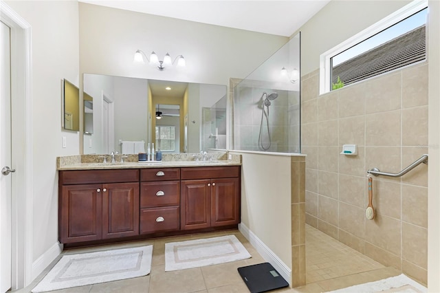 bathroom with ceiling fan, vanity, tile patterned floors, and tiled shower