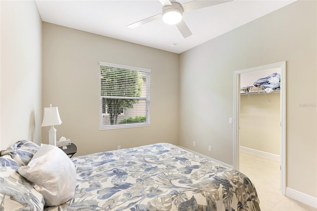 bedroom with light tile patterned flooring, a spacious closet, ceiling fan, and a closet