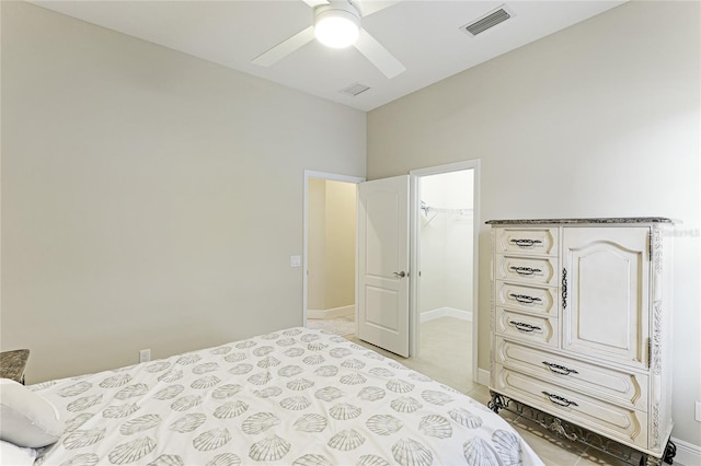 bedroom with a spacious closet, a closet, ceiling fan, and light carpet