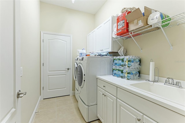 clothes washing area with cabinets, sink, washing machine and dryer, and light tile patterned flooring