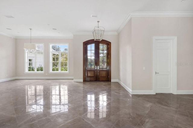 entrance foyer with an inviting chandelier, french doors, and crown molding