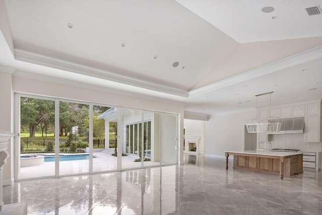 unfurnished living room with lofted ceiling, crown molding, and a healthy amount of sunlight