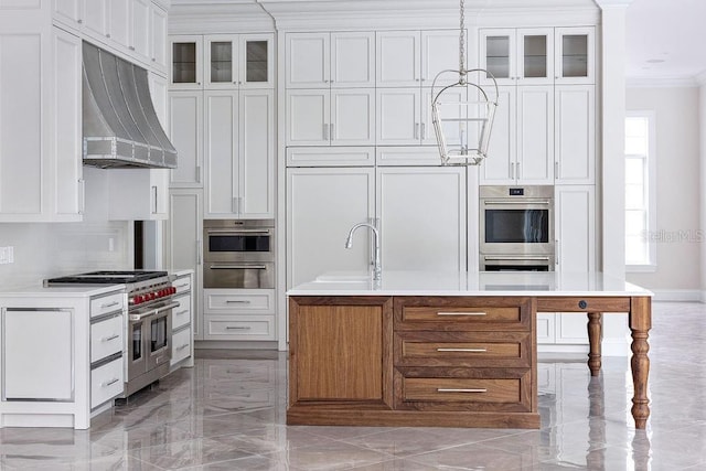 kitchen with an island with sink, white cabinets, stainless steel appliances, ventilation hood, and ornamental molding