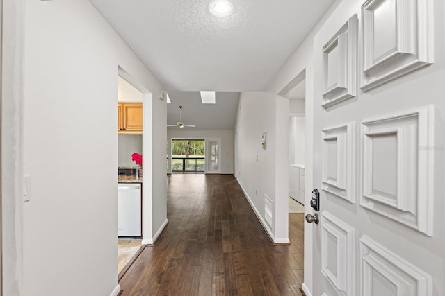 corridor with lofted ceiling, a textured ceiling, and dark wood-type flooring