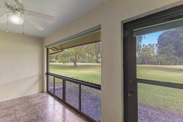 unfurnished sunroom with ceiling fan