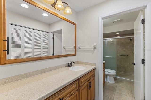 bathroom with tile patterned floors, toilet, vanity, and walk in shower