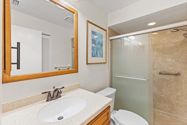 bathroom with vanity, toilet, and a shower with door