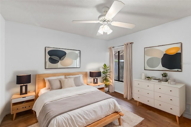 bedroom with dark hardwood / wood-style flooring and ceiling fan