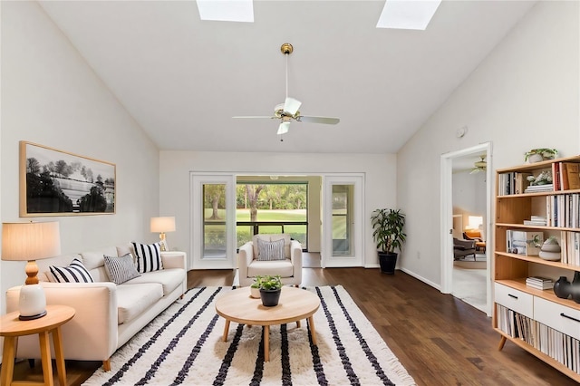 living room featuring dark hardwood / wood-style flooring, a skylight, high vaulted ceiling, and ceiling fan