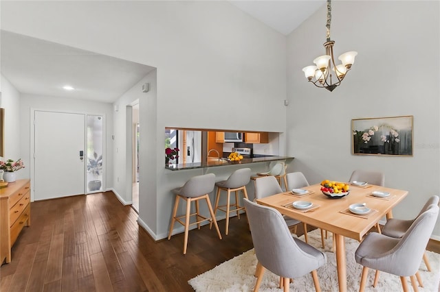 dining area with a chandelier, dark hardwood / wood-style flooring, and vaulted ceiling