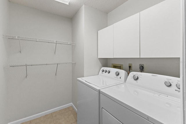 clothes washing area featuring cabinets, light tile patterned floors, washing machine and dryer, and a textured ceiling