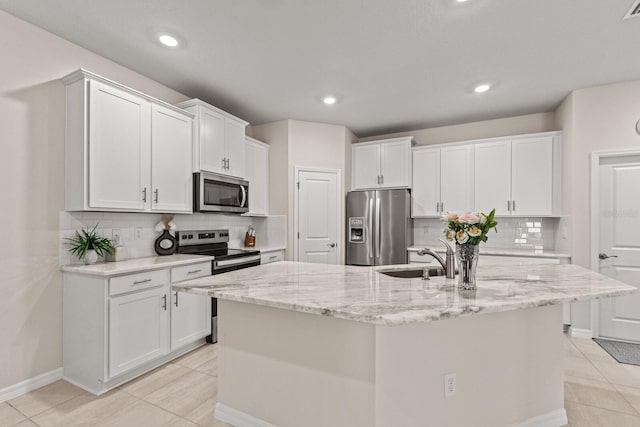 kitchen with an island with sink, white cabinetry, sink, and stainless steel appliances