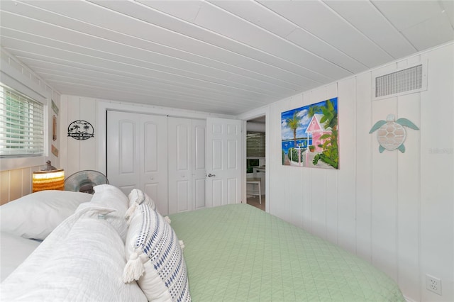 bedroom featuring wooden walls and a closet