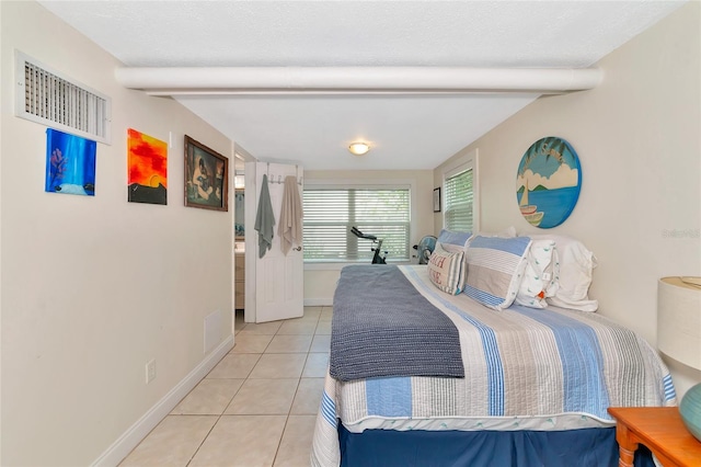 tiled bedroom with a textured ceiling and beam ceiling