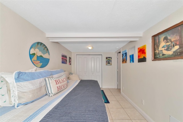 tiled bedroom with a textured ceiling and a closet