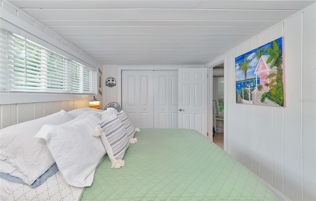 bedroom with wooden walls and a closet