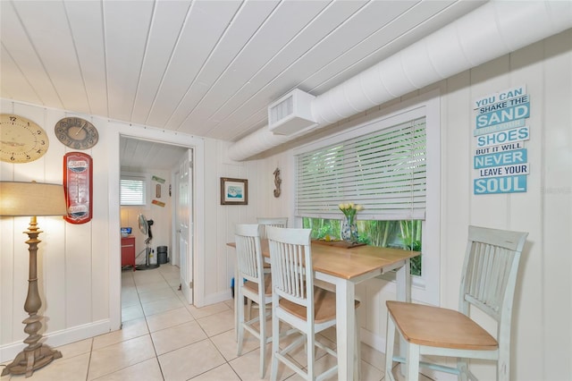 dining area with wooden walls, light tile patterned floors, and wooden ceiling