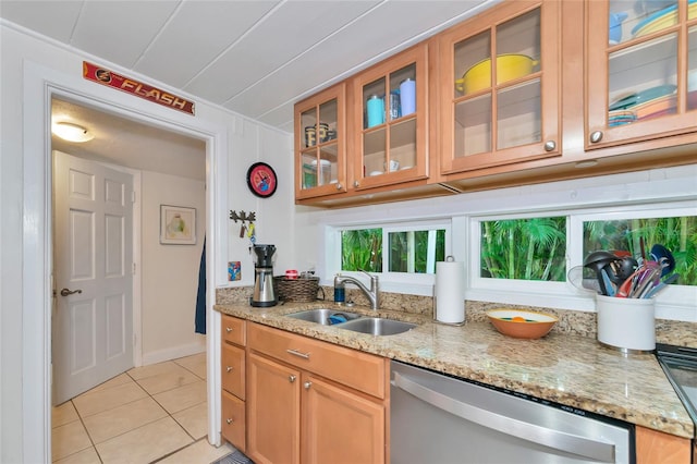 kitchen with stainless steel dishwasher, light stone countertops, sink, and light tile patterned flooring