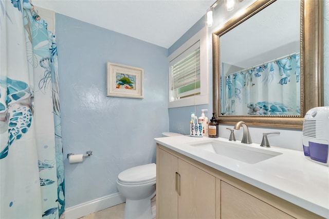 bathroom with toilet, vanity, tile patterned flooring, and walk in shower