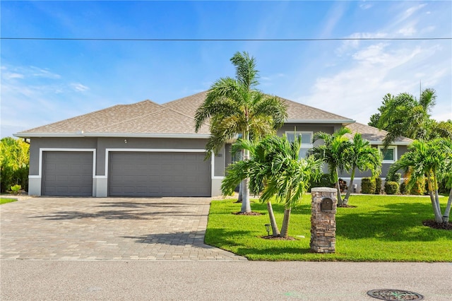 view of front of property featuring a front lawn and a garage