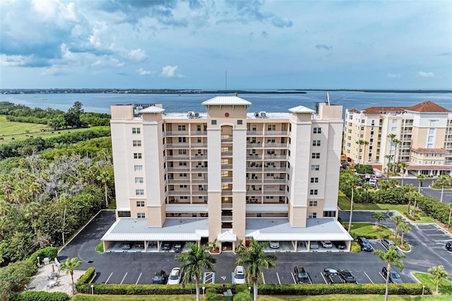 view of building exterior with a water view and uncovered parking