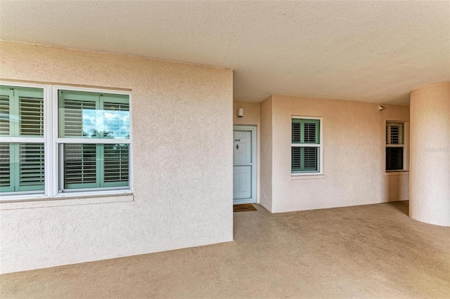 exterior space featuring carpet floors and a textured ceiling