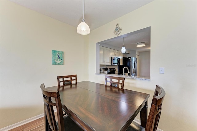 dining space featuring baseboards and wood finished floors