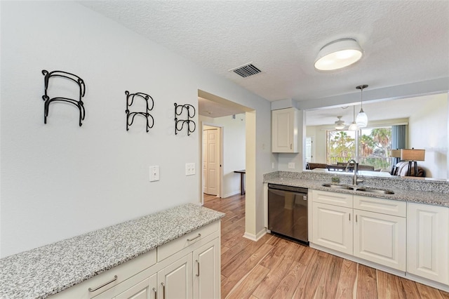 kitchen with dishwasher, sink, hanging light fixtures, light hardwood / wood-style flooring, and light stone countertops