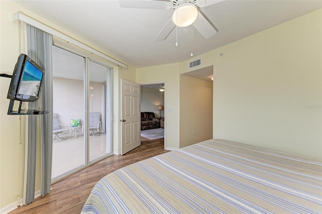 bedroom with ceiling fan, access to exterior, a textured ceiling, and light hardwood / wood-style floors